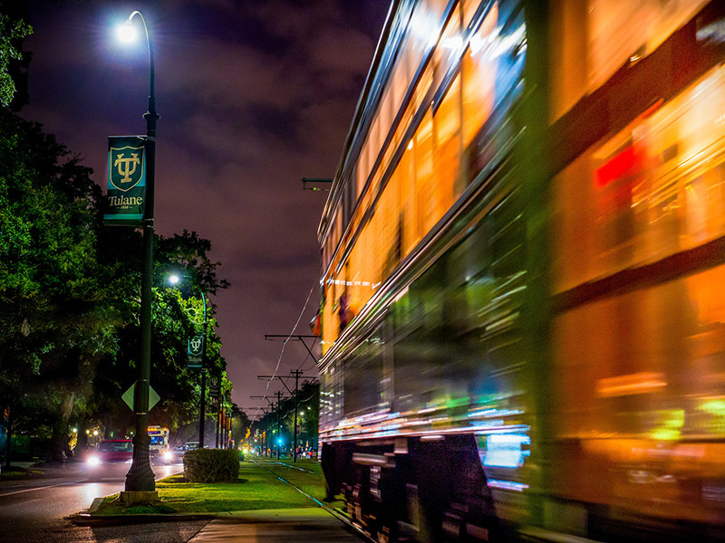 The streetcar passes by at night in front of Tulane. 